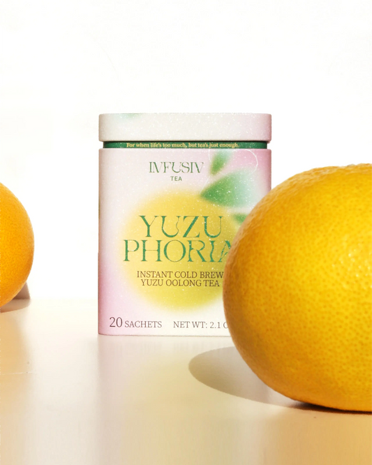 Yuzuphoria tea tin box with yuzu fruits on a white background